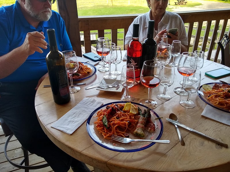 Image of Otter Club members enjoying a meal and wine at the Flying Otter tasting room.