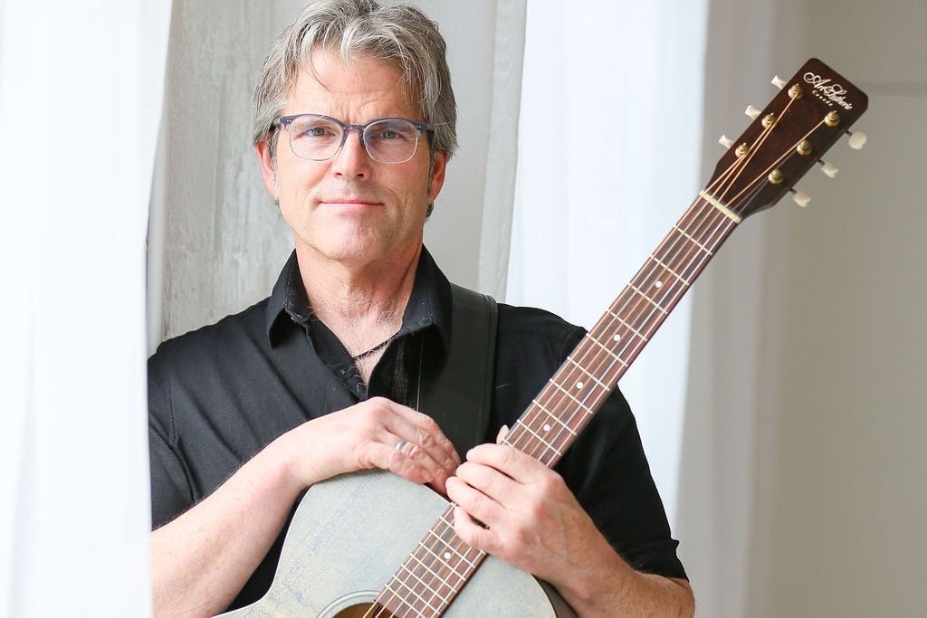 Photo of Terry Farmer holding a guitar